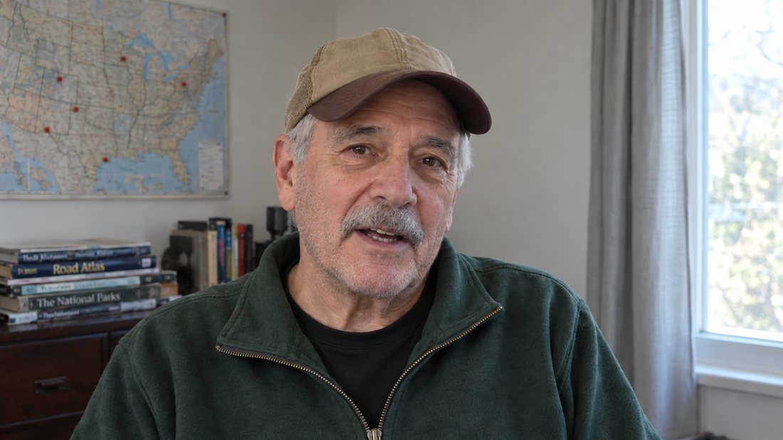 Glen Hollins at his desk under a pinned map of the United States